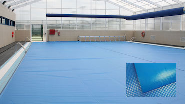 Piscina pública climatizada interior, con cobertor térmico de espuma con enrollador para conservar la temperatura durante las horas de no utilización. Piscina climatizada en Madrid, interior, con un cobertor térmico flotante de espuma con enrollador.