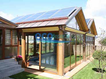Estructura a medida para la cubierta y así poder colocar perfectamente las placas solares orientadas al sur. Exterior de una piscina climatizada con una cubierta acristalada a medida y placas solares para el calentamiento del agua.