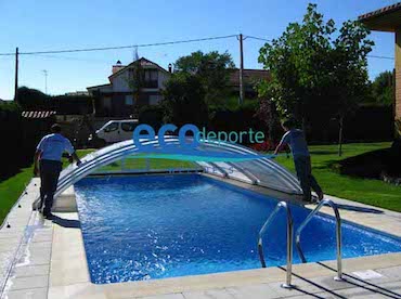 Apertura fácil. Gran resistencia al viento. Dos personas, una por cada lado, empujando una cubierta baja telescópica de piscina para abrirla.