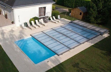La cubierta de piscina más discreta. ¡Cuidado si la instalas en una zona de grandes nevadas! Vista cenital de una piscina con una cubierta acristalada plana telescópica motorizada.