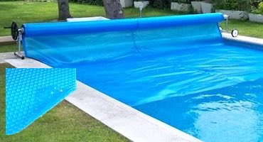 Piscina exterior de verano con un cobertor de burbuja de doble función: aumentar la temperatura del agua durante las horas de sol y evitar que se enfríe por la noche. Piscina exterior con un cobertor flotante de burbuja con enrollador manual.