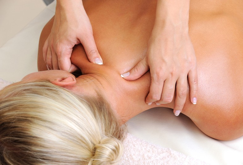 Fisioterapeuta realizando un masaje de cuello y cervicales a un paciente tumbado Fisioterapeuta realizando un masaje de cuello y cervicales a un paciente tumbado