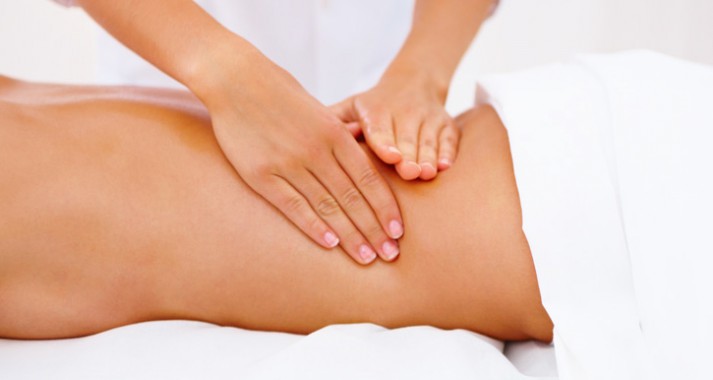Fisioterapeuta realizando un masaje sobre la zona lumbar Fisioterapeuta realizando un masaje sobre la zona lumbar