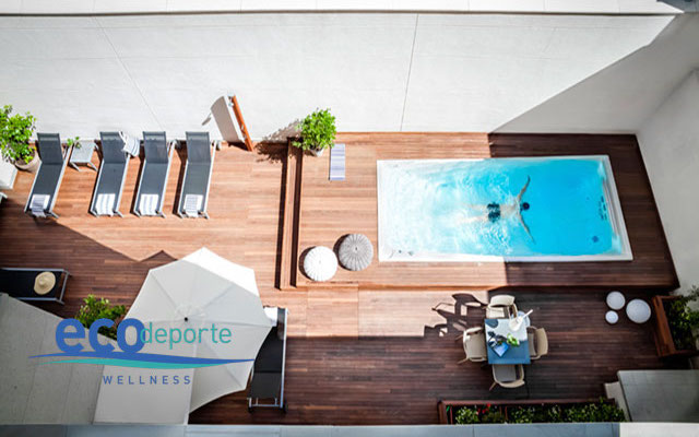 Nado contracorriente en mi terraza Vista cenital de swim spa en una terrzada de hotel con un bañista dentro nadando a contracorriente
