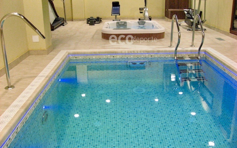 Piscina sin mantenimiento, solo para disfrutar. En primer plano la minipiscina y al fondo el spa jacuzzi con el gimnasio.
