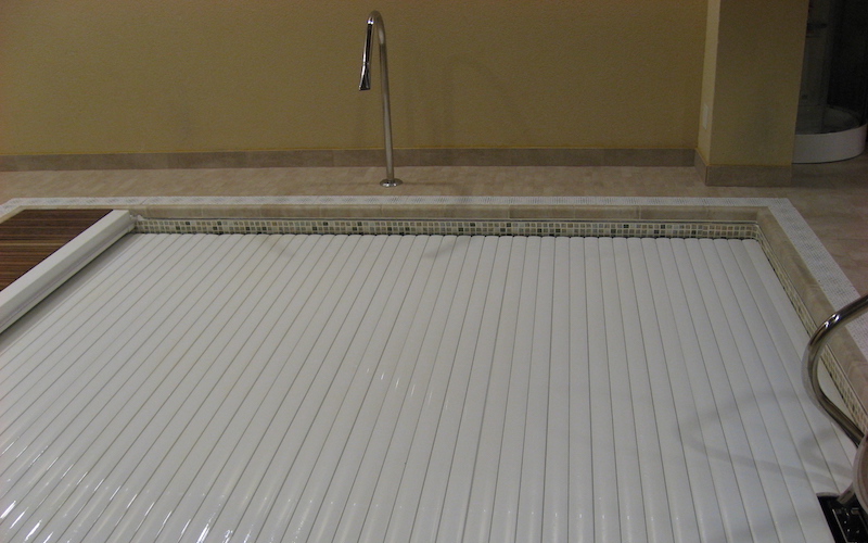 Se adapta a los pasamanos de la escalera de acceso fácil. Mini piscina interior con la cubierta de lamas extendida.