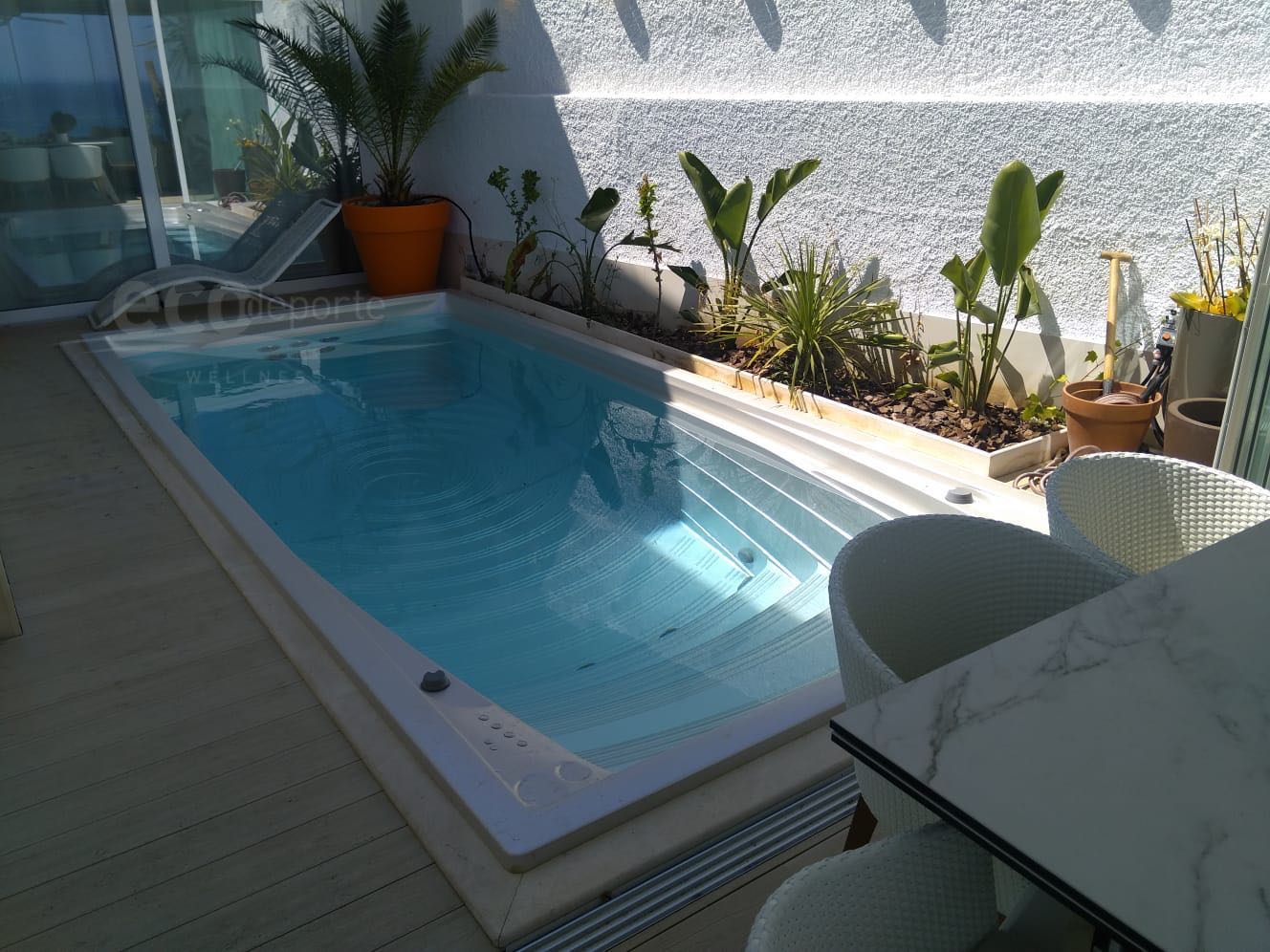 Intimidad en esta zona de baño, privada Patio interior de una casa con paredes encaladas donde se ha instalado un swim spa empotrado
